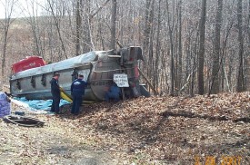 Tanker on its side next to trees